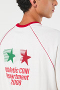 Camiseta oversize crema con diseños college y cuello redondo