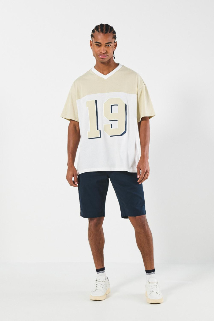 Camiseta college cuello V crema clara oversize