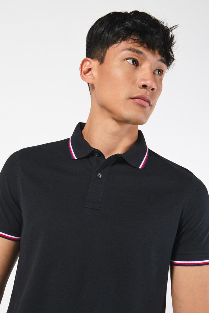 Camiseta negra polo con manga corta y rayas blancas