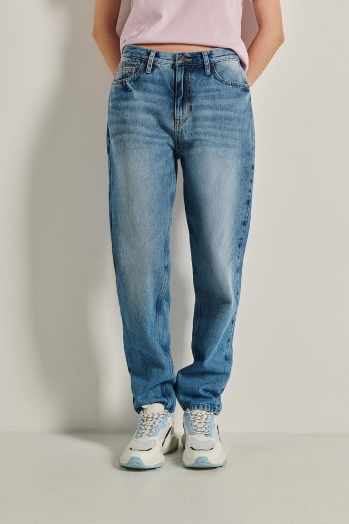 Jean tiro alto boyfriend azul con bota recta y desgastes