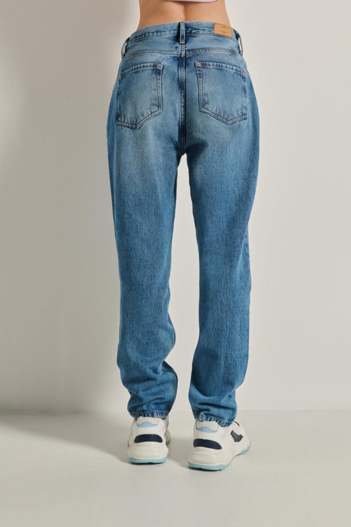 Jean tiro alto boyfriend azul con bota recta y desgastes
