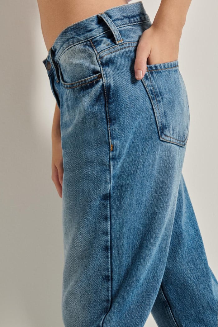 Jean tiro alto boyfriend azul con bota recta y desgastes