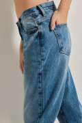 Jean tiro alto boyfriend azul con bota recta y desgastes