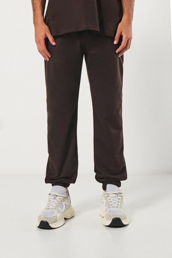 Pantalón unicolor jogger con bolsillos y elástico en bota