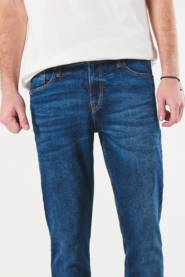 Jean azul oscuro slim con desgastes sutiles y tiro bajo