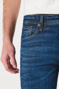 Jean azul oscuro slim con desgastes sutiles y tiro bajo