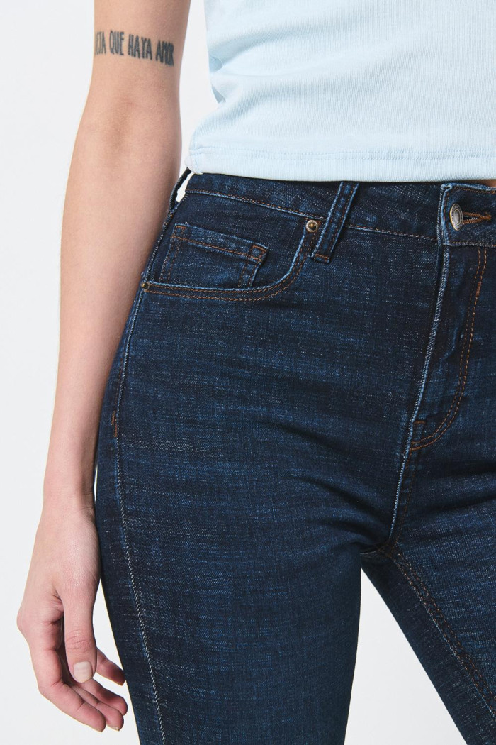Jean tiro alto jegging azul intenso con costuras cafés