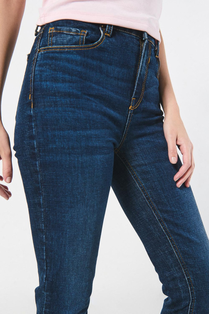 Jean jegging ceñido azul oscuro tiro alto con costuras cafés