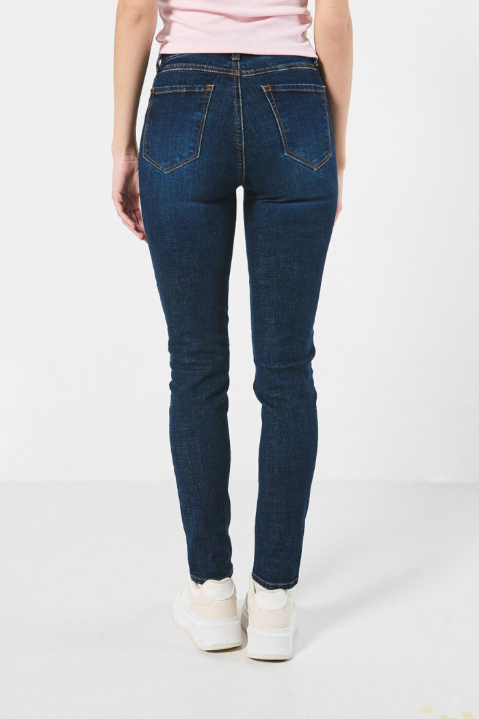 Jean jegging ceñido azul oscuro tiro alto con costuras cafés