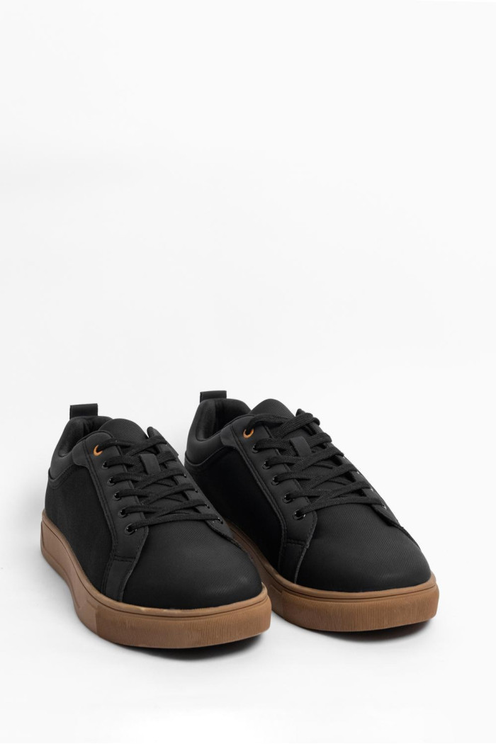 Tenis negros casuales con texturas y suelas en contraste