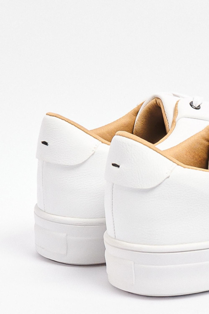 Tenis casuales blancos con suelas planas y contrastes