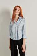 Blusa azul con cuello camisero, manga 3/4 y flores blancas