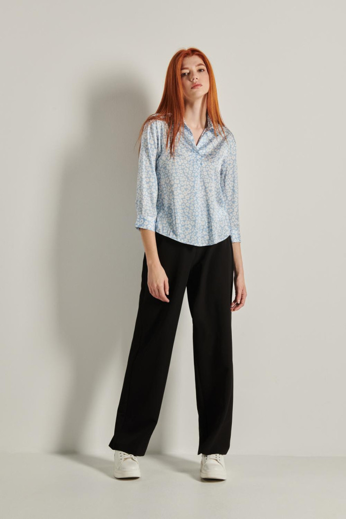 Blusa azul con cuello camisero, manga 3/4 y flores blancas