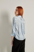 Blusa azul con cuello camisero, manga 3/4 y flores blancas
