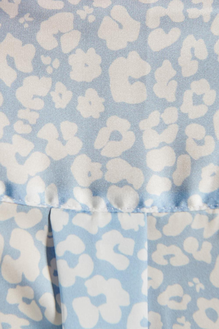 Blusa azul con cuello camisero, manga 3/4 y flores blancas