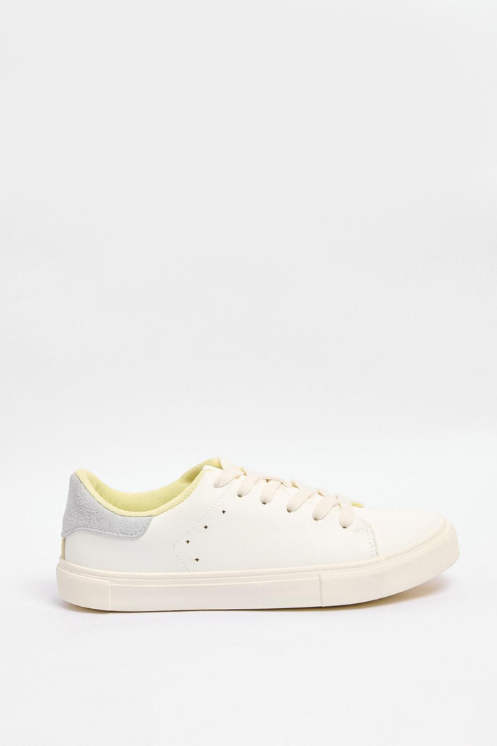 Tenis blancos casuales con talón gris y perforaciones