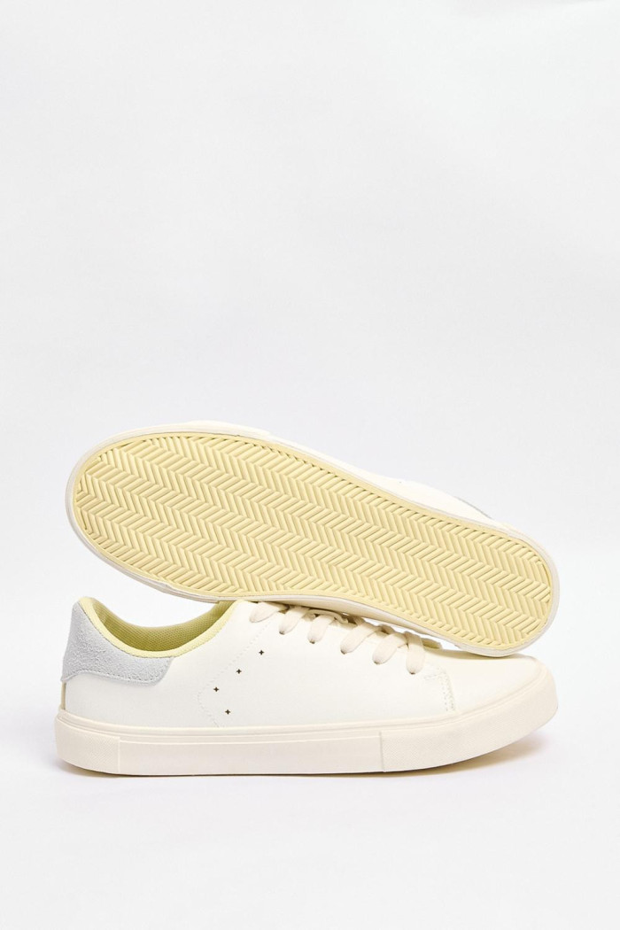 Tenis blancos casuales con talón gris y perforaciones