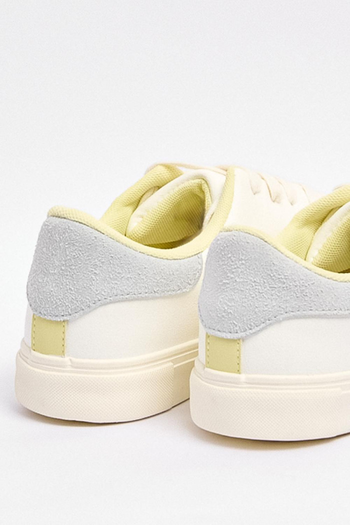 Tenis blancos casuales con talón gris y perforaciones