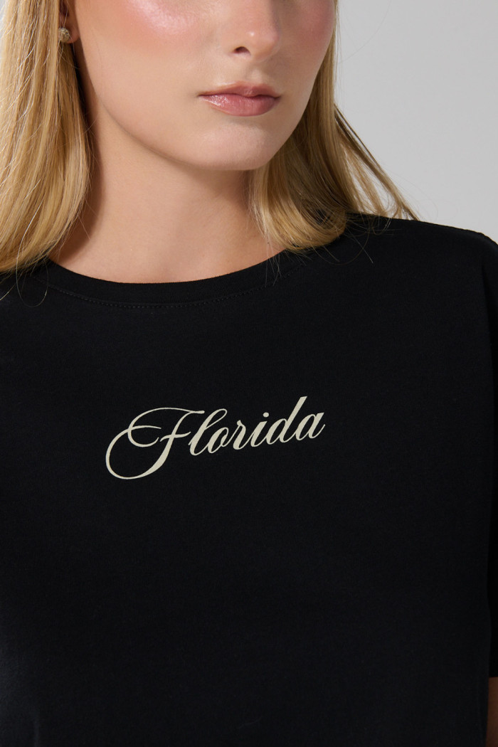 Camiseta negra con texto college y cuello redondo