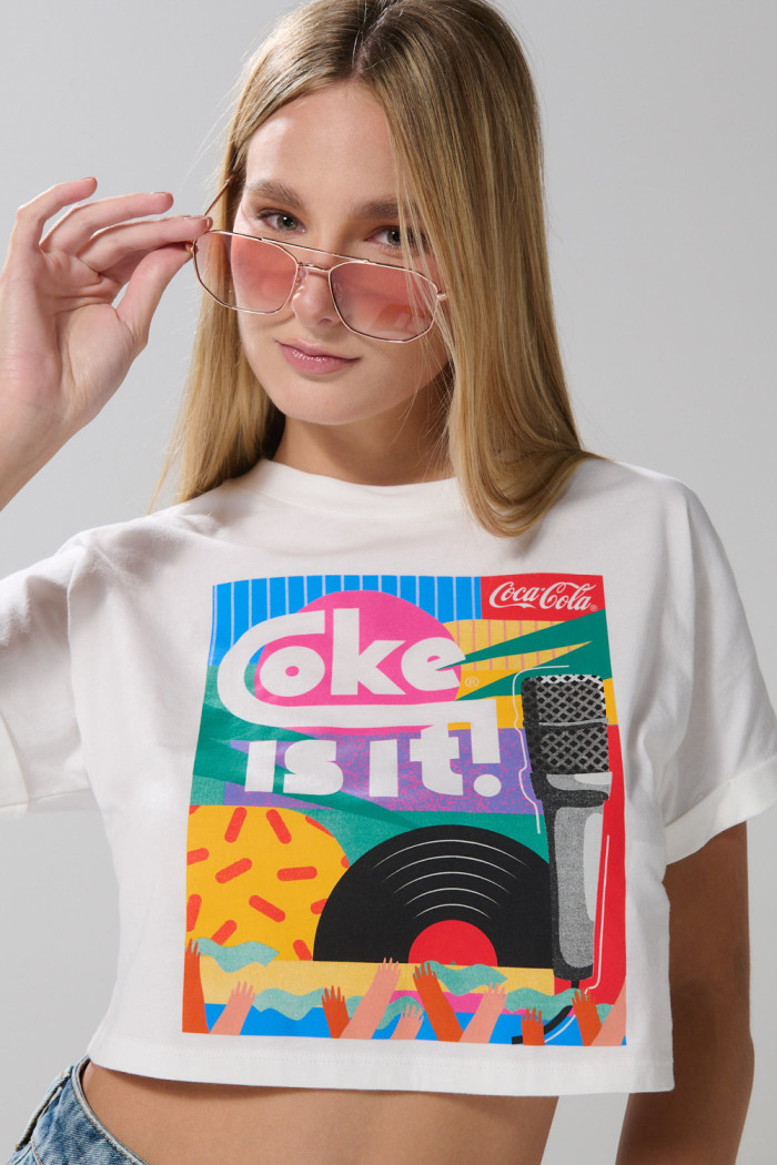 Camiseta crema clara crop top con arte de Coca-Cola
