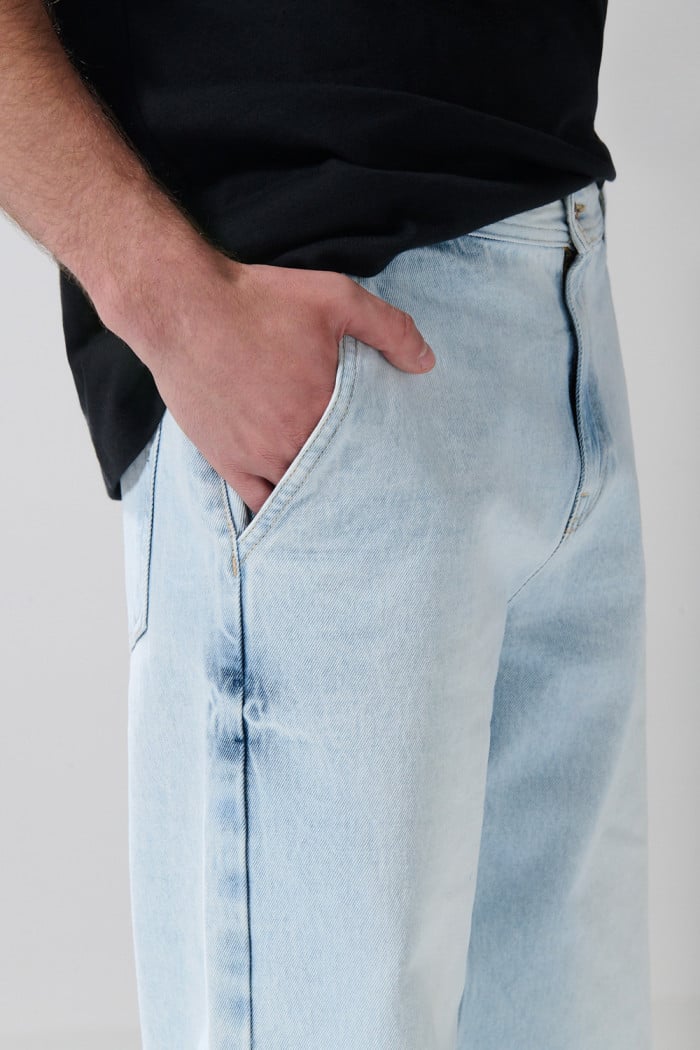 Jean skater azul con desgastes, bota ancha y tiro medio