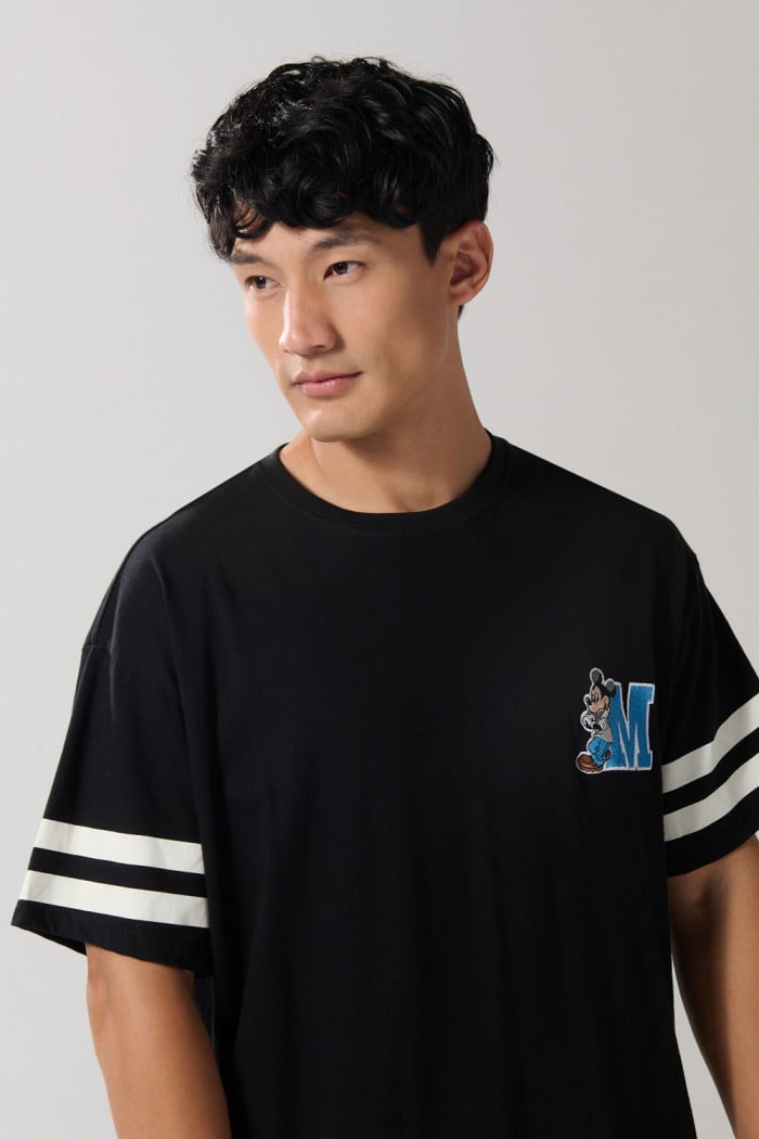 Camiseta negra oversize cuello redondo con arte de Mickey