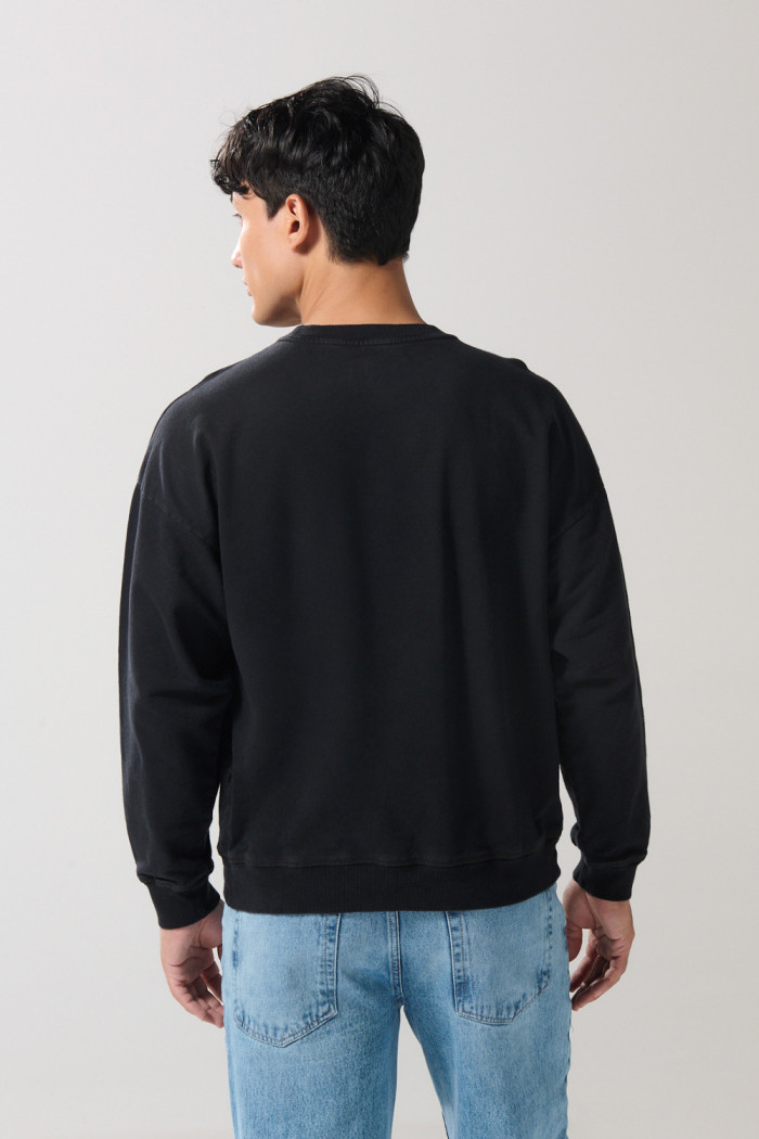 Buzo unicolor cuello redondo oversize con bolsillo