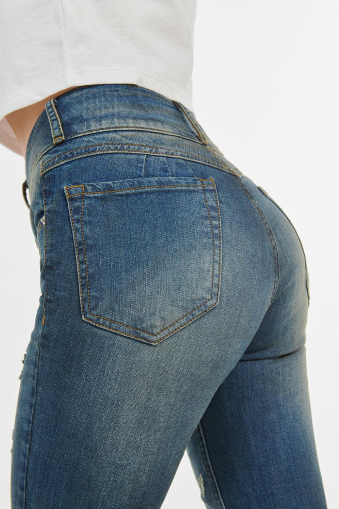 Jean push up tiro alto azul medio claro con rotos.