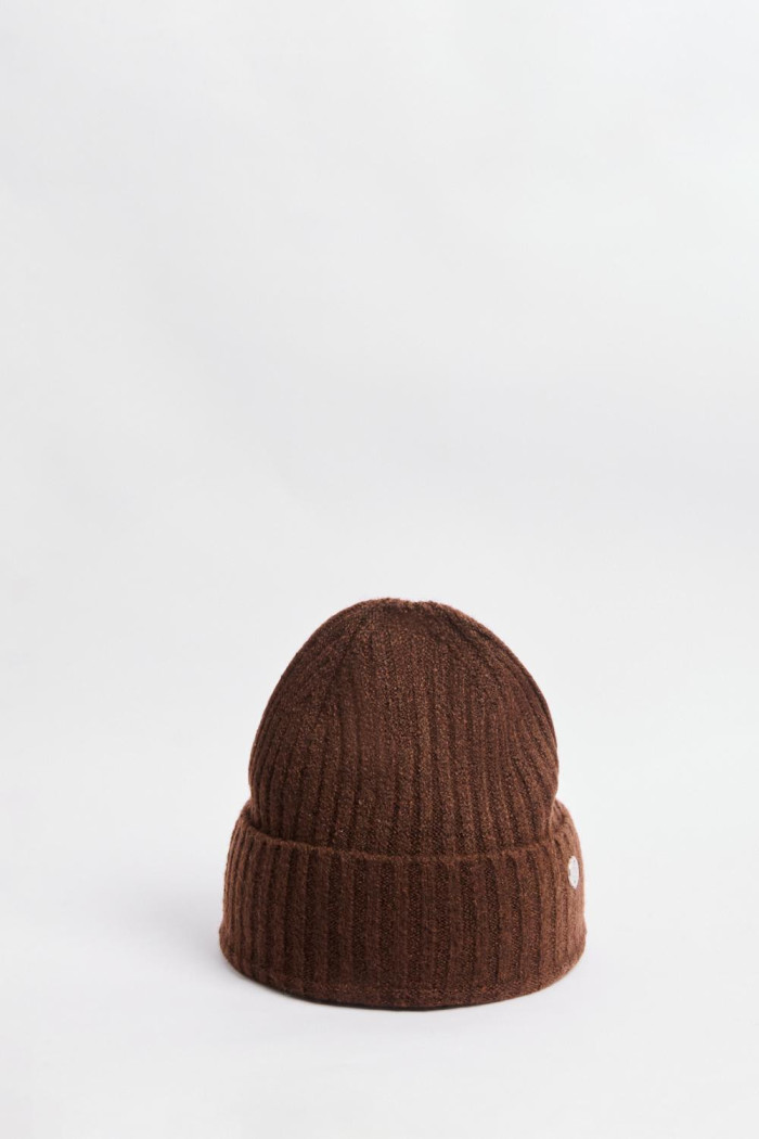 Gorro tejido unicolor con dije decorativo