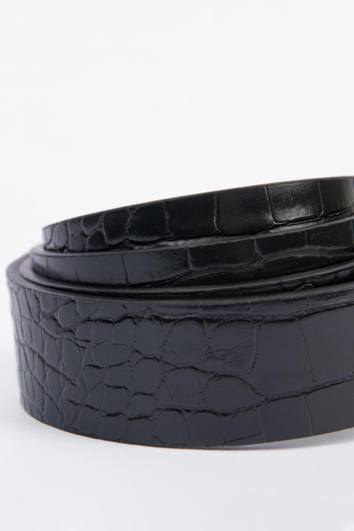 Cinturón negro con hebilla ovalada dorada y texturas
