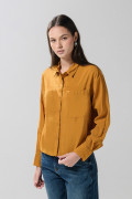 Blusa unicolor con doble bolsillo, manga larga y botones