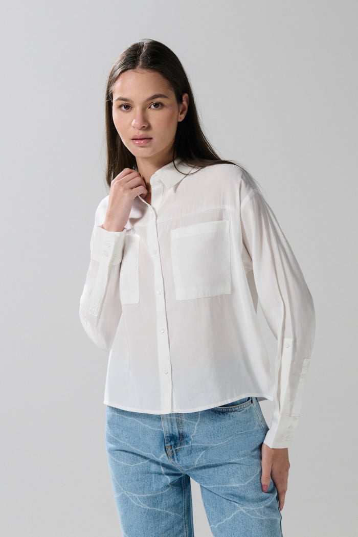 Blusa unicolor con doble bolsillo, manga larga y botones