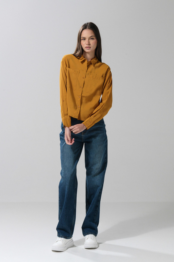 Blusa unicolor con doble bolsillo, manga larga y botones