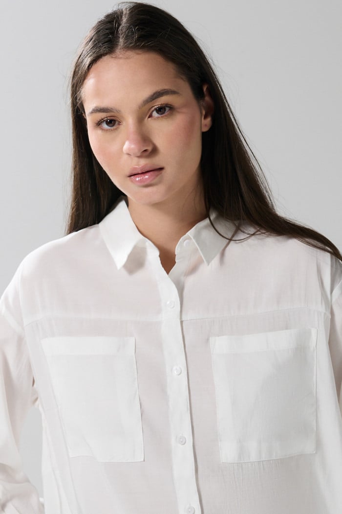 Blusa unicolor con doble bolsillo, manga larga y botones