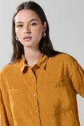 Blusa unicolor con doble bolsillo, manga larga y botones