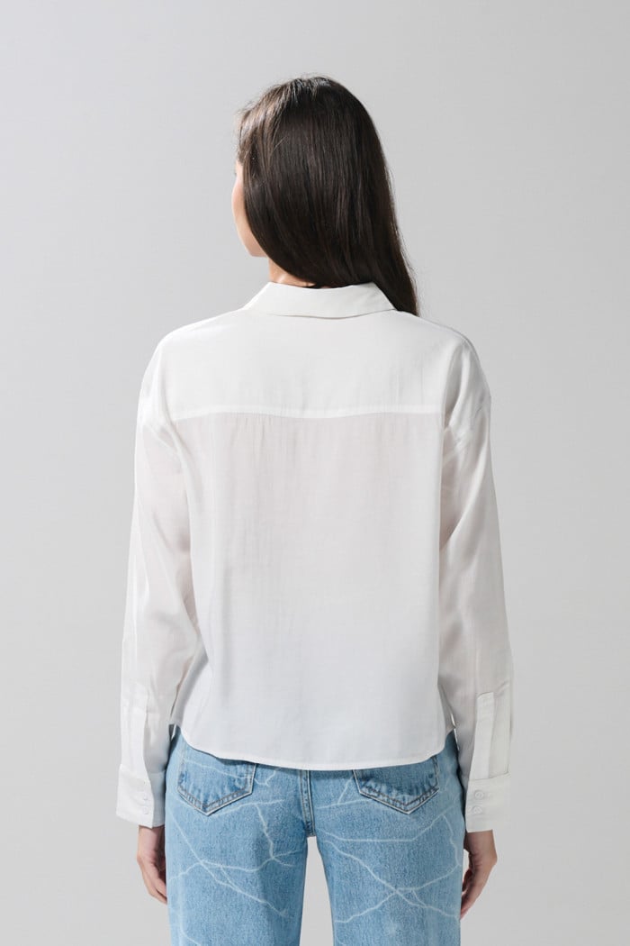 Blusa unicolor con doble bolsillo, manga larga y botones