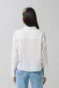 Blusa unicolor con doble bolsillo, manga larga y botones