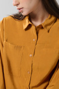 Blusa unicolor con doble bolsillo, manga larga y botones