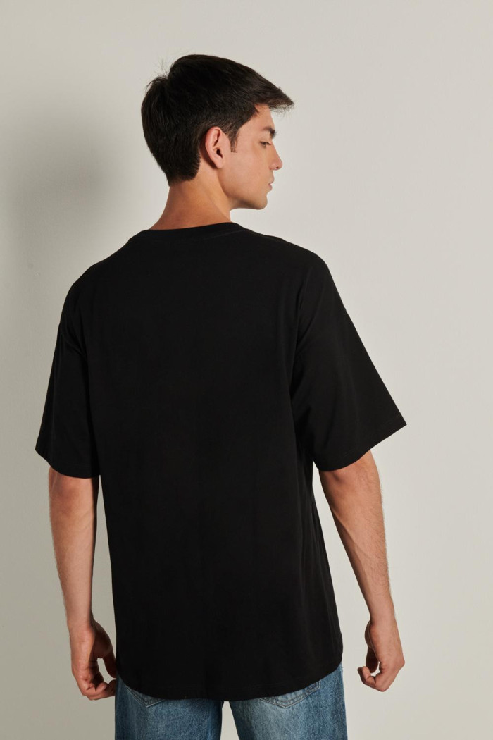 Camiseta negra oversize con manga corta y diseño en frente