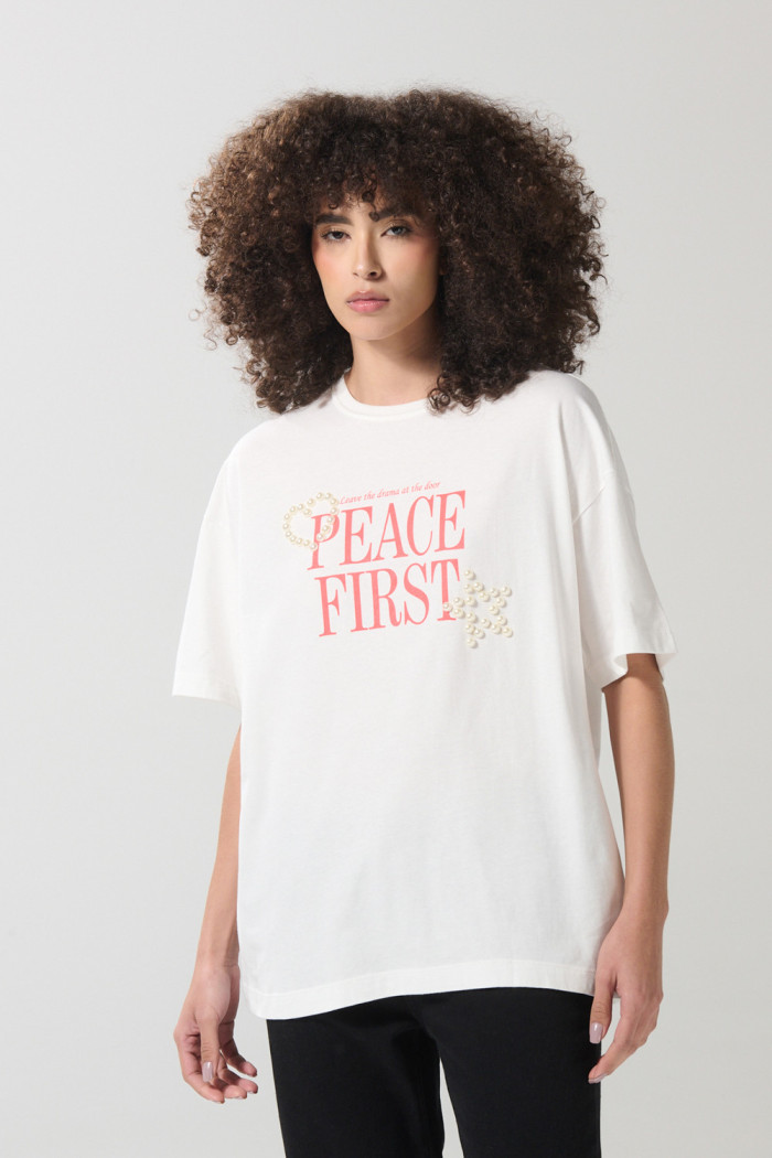 Camiseta crema oversize con texto en frente y manga corta