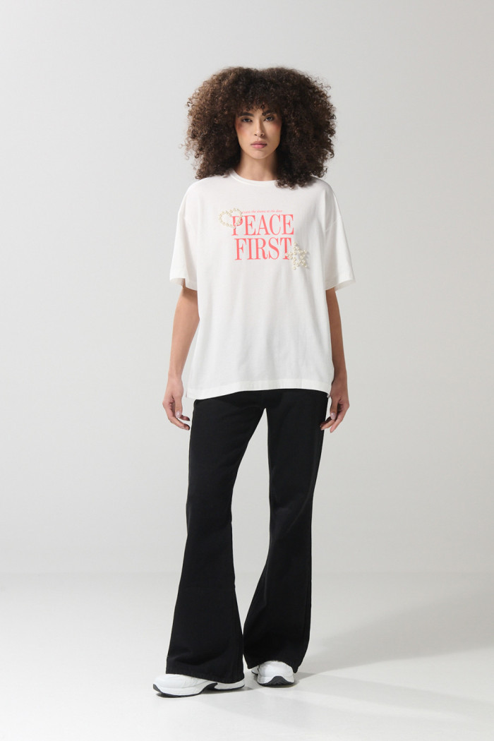 Camiseta crema oversize con texto en frente y manga corta