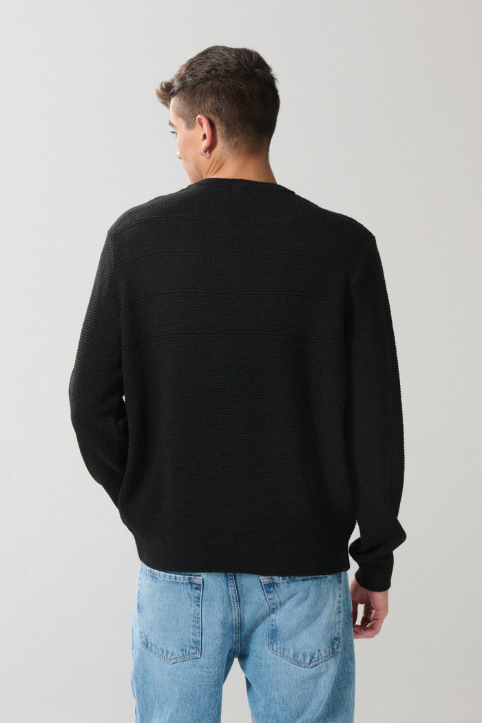 Suéter tejido negro con cuello redondo y rayas en relieve