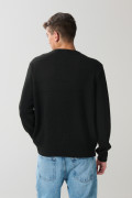 Suéter tejido negro con cuello redondo y rayas en relieve