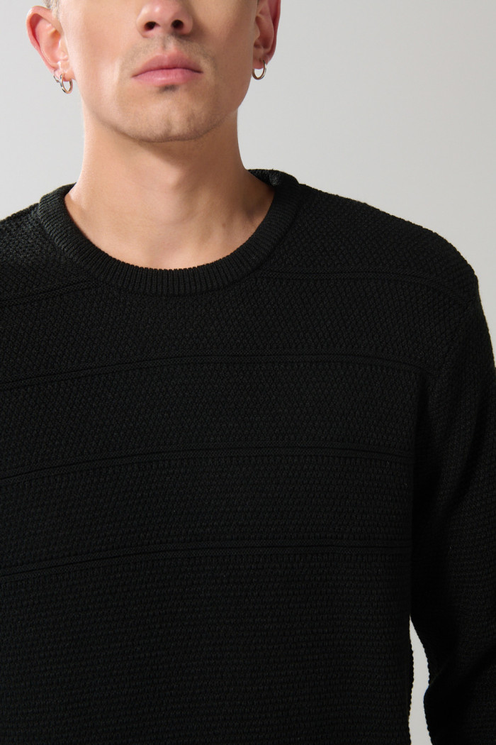 Suéter tejido negro con cuello redondo y rayas en relieve