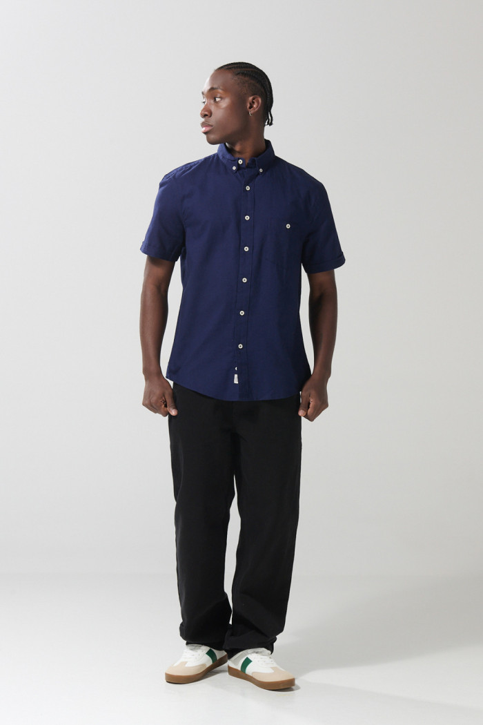Camisa unicolor con bolsillo en frente y cuello button down