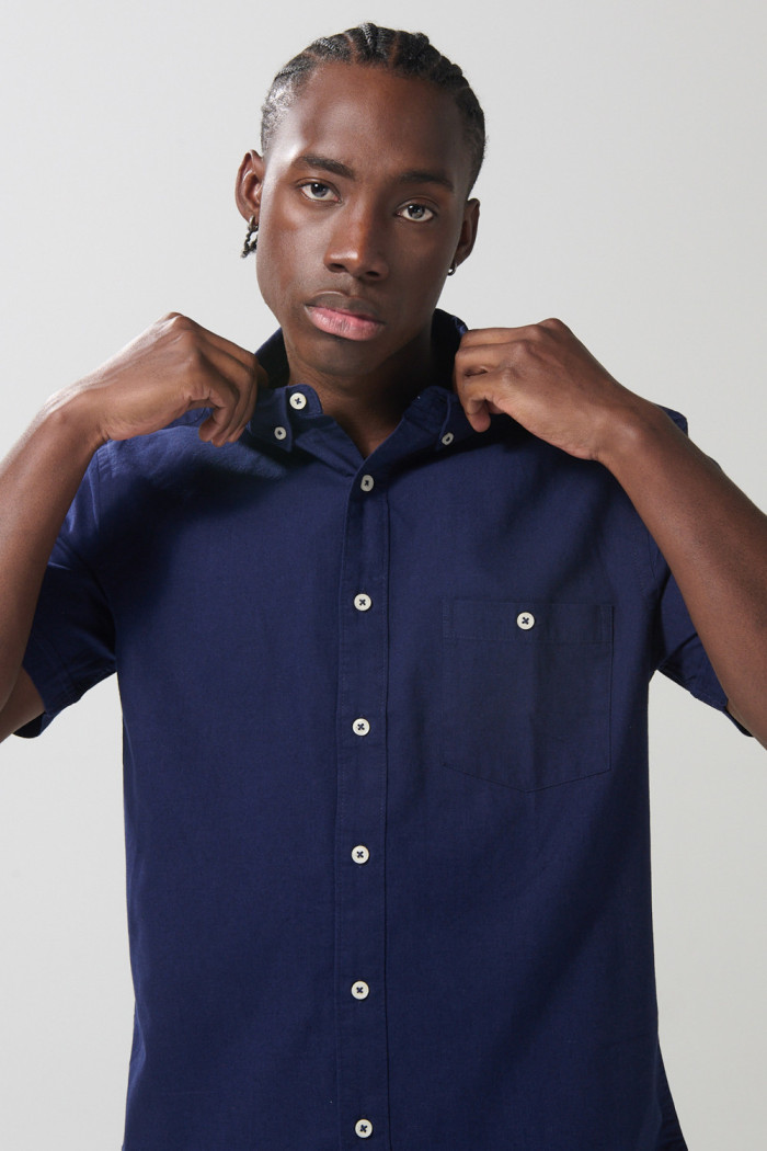 Camisa unicolor con bolsillo en frente y cuello button down
