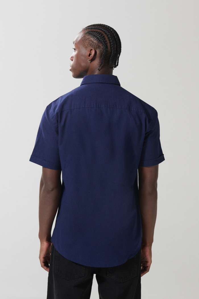 Camisa unicolor con bolsillo en frente y cuello button down