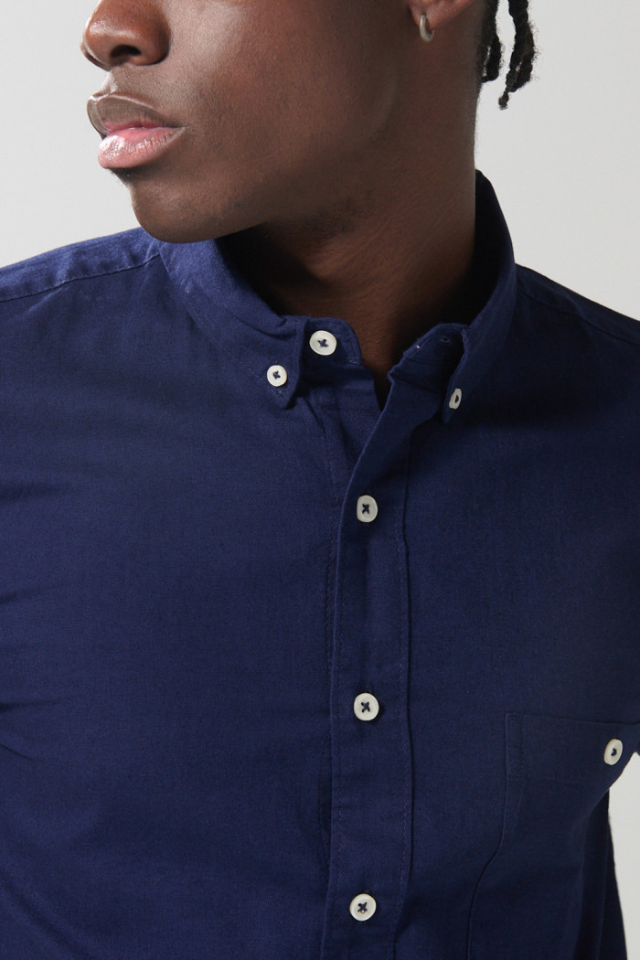 Camisa unicolor con bolsillo en frente y cuello button down