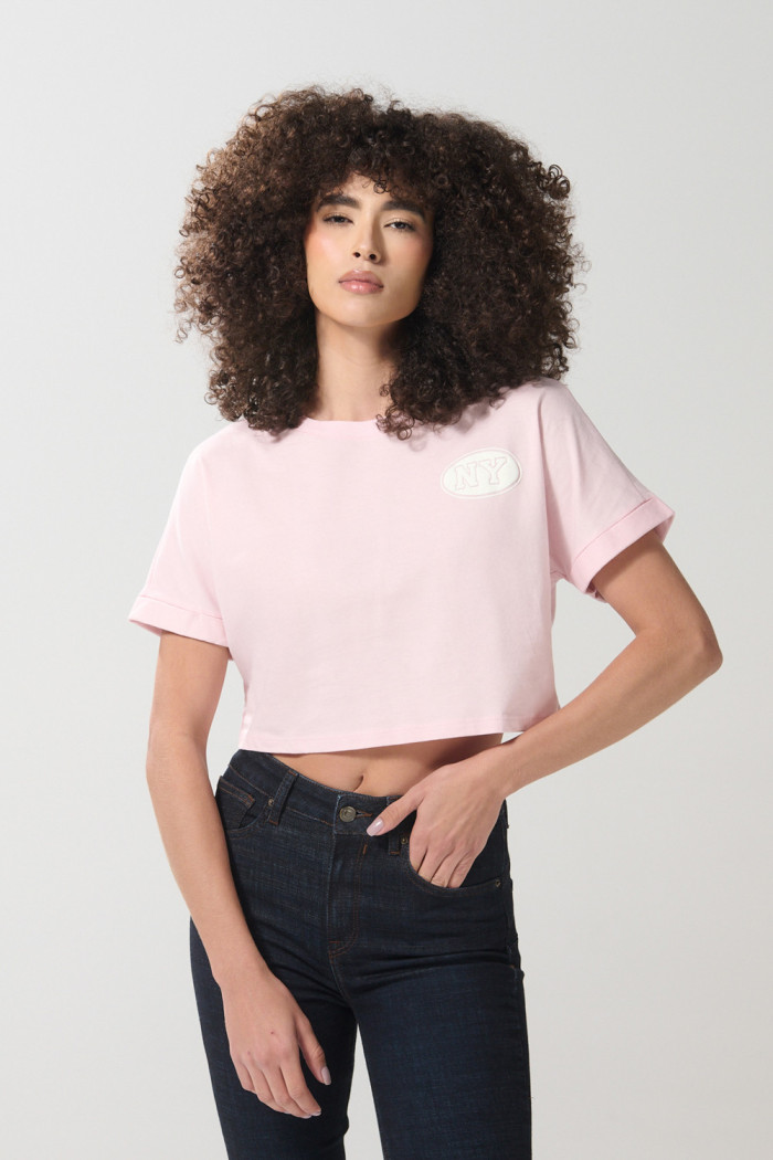 Camiseta crop top rosada clara con diseños college