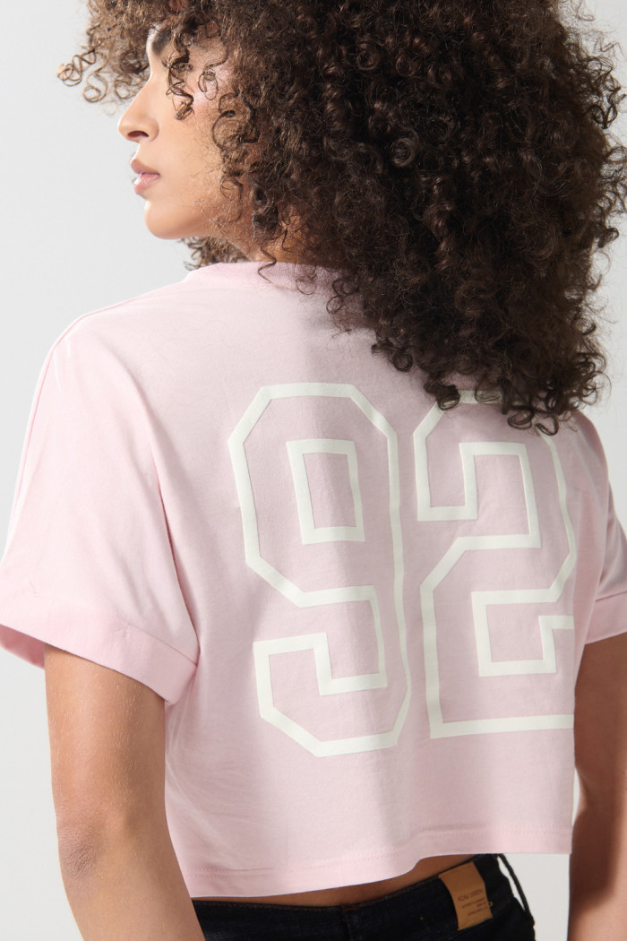Camiseta crop top rosada clara con diseños college
